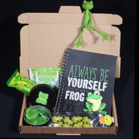 Opkikker-brievenbuscadeautje van De Verrassingsmand met thee, kikkersnoepjes, chocolade, schrift en een vrolijke kikker