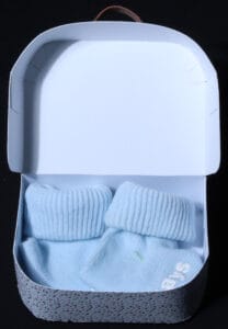 Logeerkoffertje met blauwe babysokjes in speciaal doosje